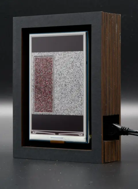The object, with a dark red square on a grey background on its screen.