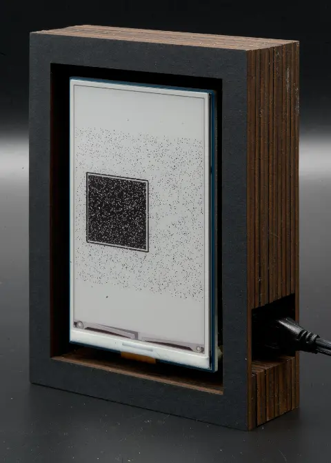 The object, showing a dark, almost black square on a very light background.