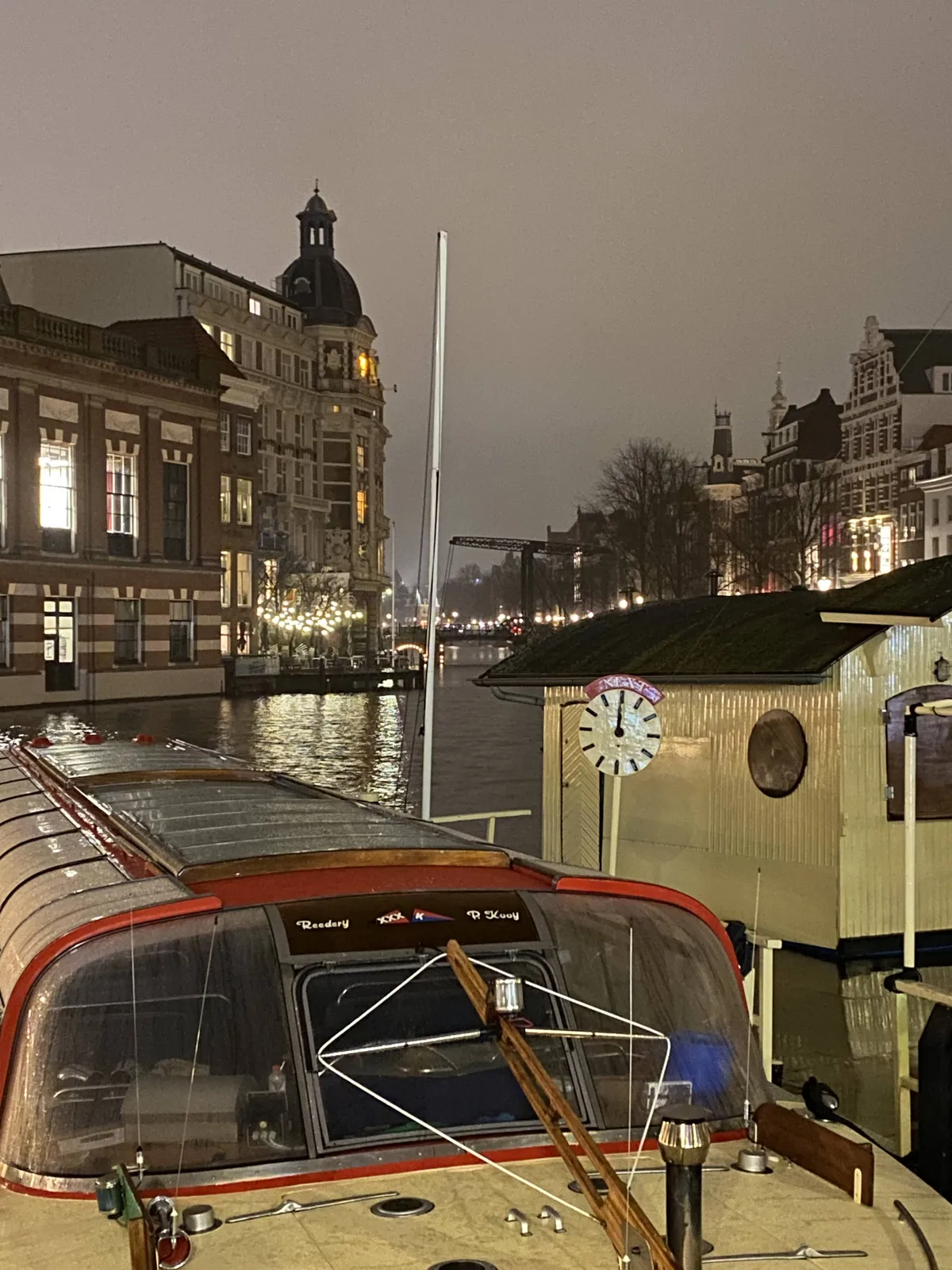 There’s a clock next to a canal boat in Amsterdam. It points up with both arms, it’s twelve o’clock.