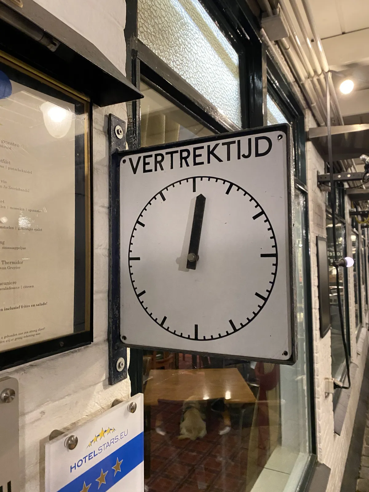A clock indicating the next departure time. It points at one minute past twelve.