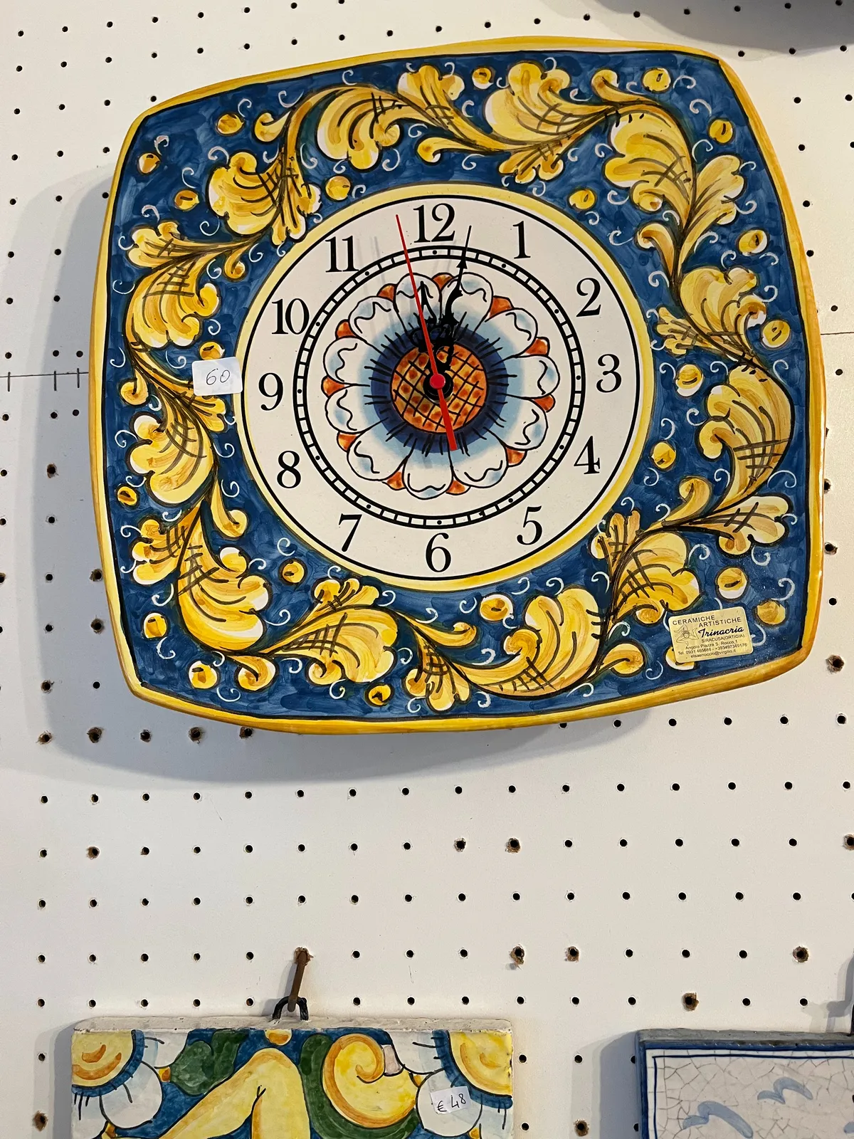 This blue ceramic plate with yellow flowers is also a clock. It is for sale for 60 euros. The time on this clock plate is two minutes past 12.