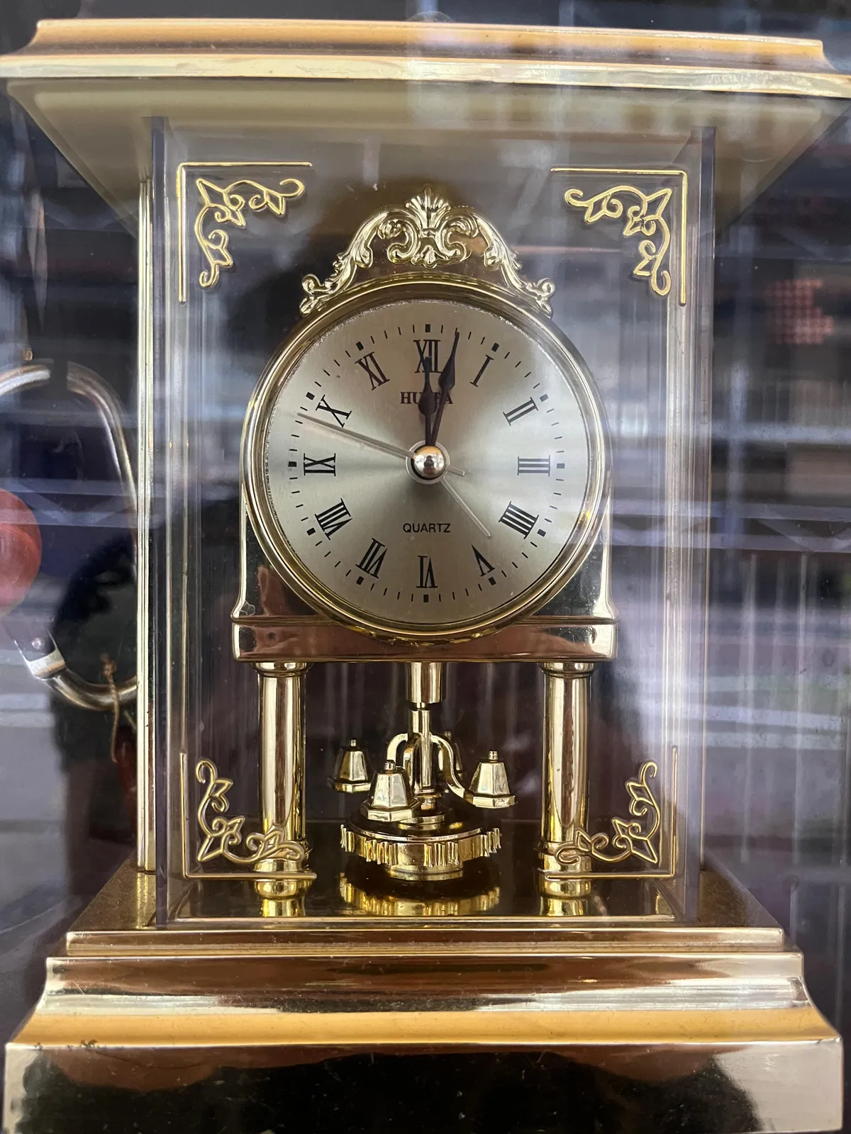 A very shiny clock, with something that looks like a golden mechanism, but probably isn’t. On the face it says Quartz, and quartz clocks don’t need mechanisms. It points at 2 minutes past 12.