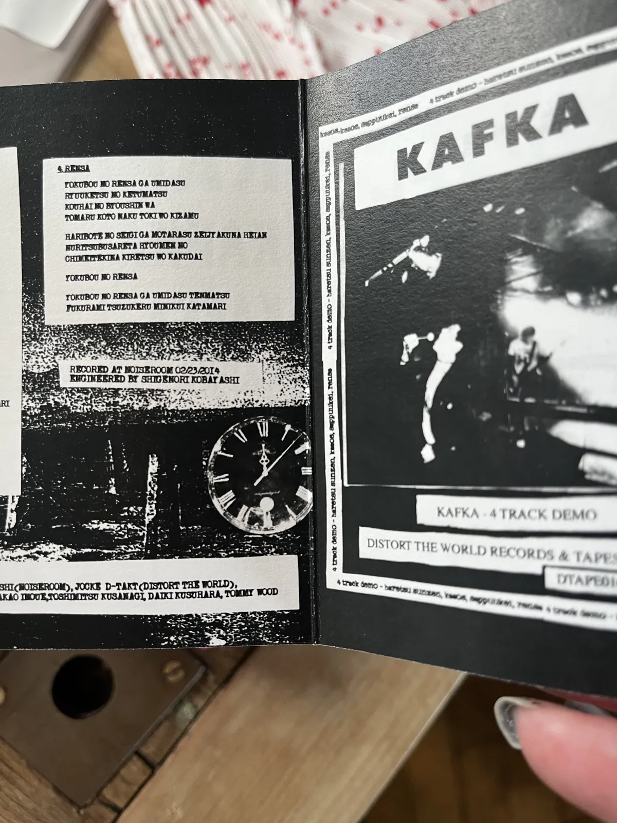 The sleeve of the four track demo by the band Kafka. The lyrics of one of the songs is printed on it, but they are not in English, and in a language I don’t know, so I’m not typing them over. There’s a picture of a clock on this sleevse, which points at seven minutes past twelve.