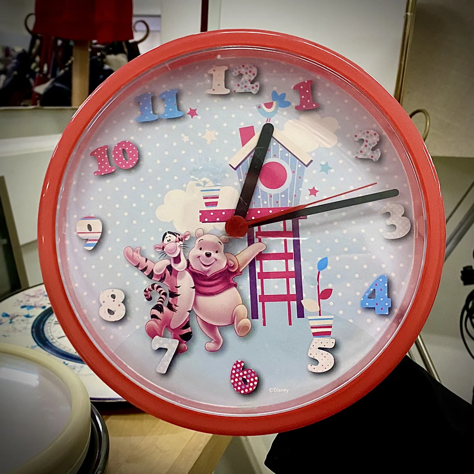 A very colourful children’s clock points at 13 past 12.