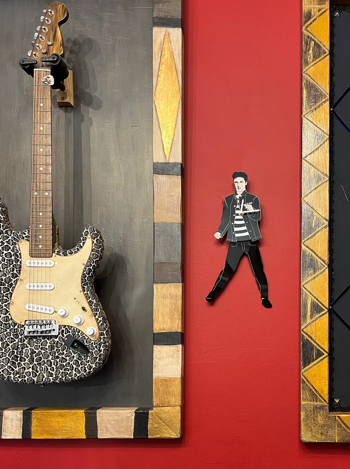 Next to a framed guitar there’s an Elvis shaped clocks, which points at 14 minutes past twelve