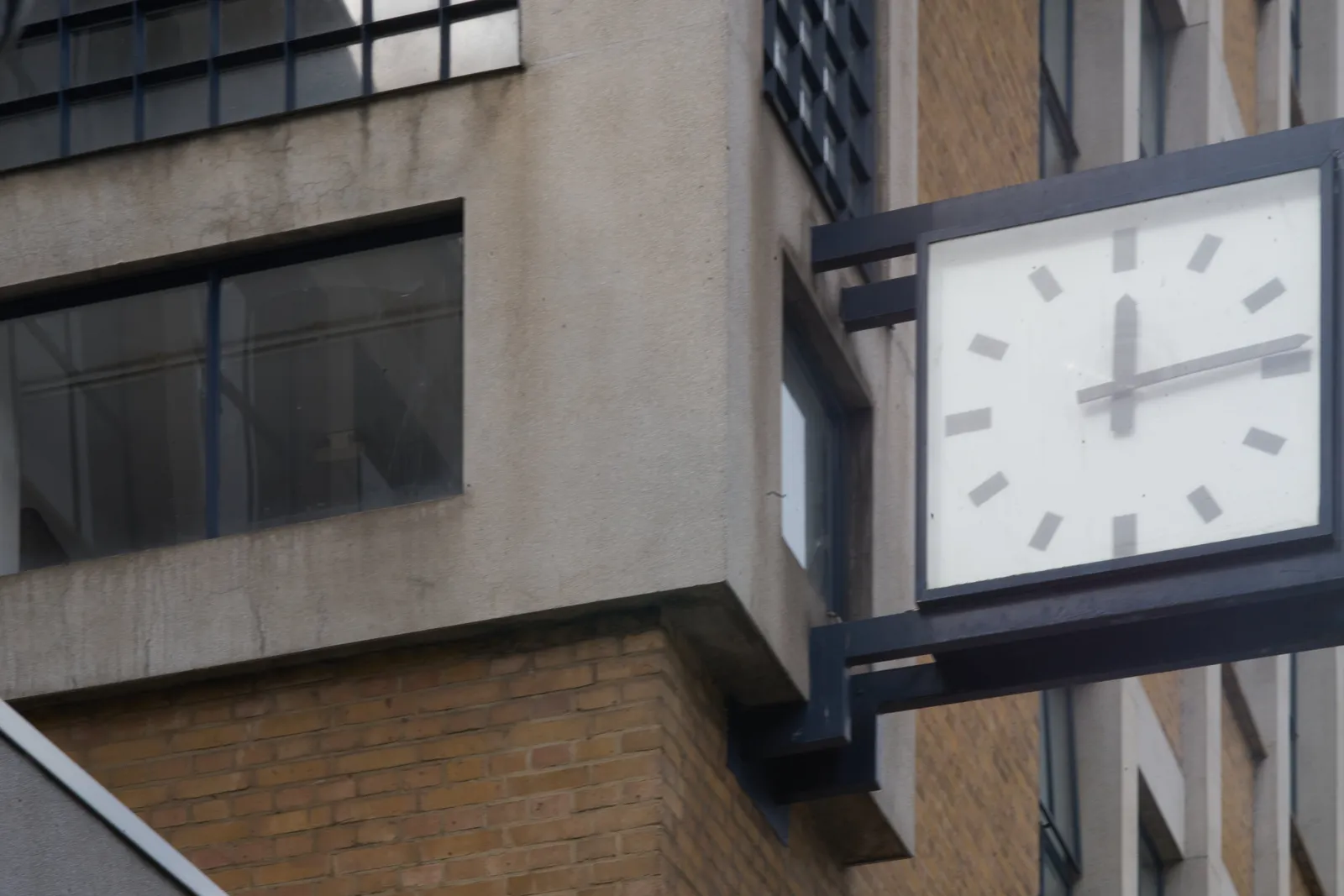 A modernist clock on a modernist building points at 14 past 12.