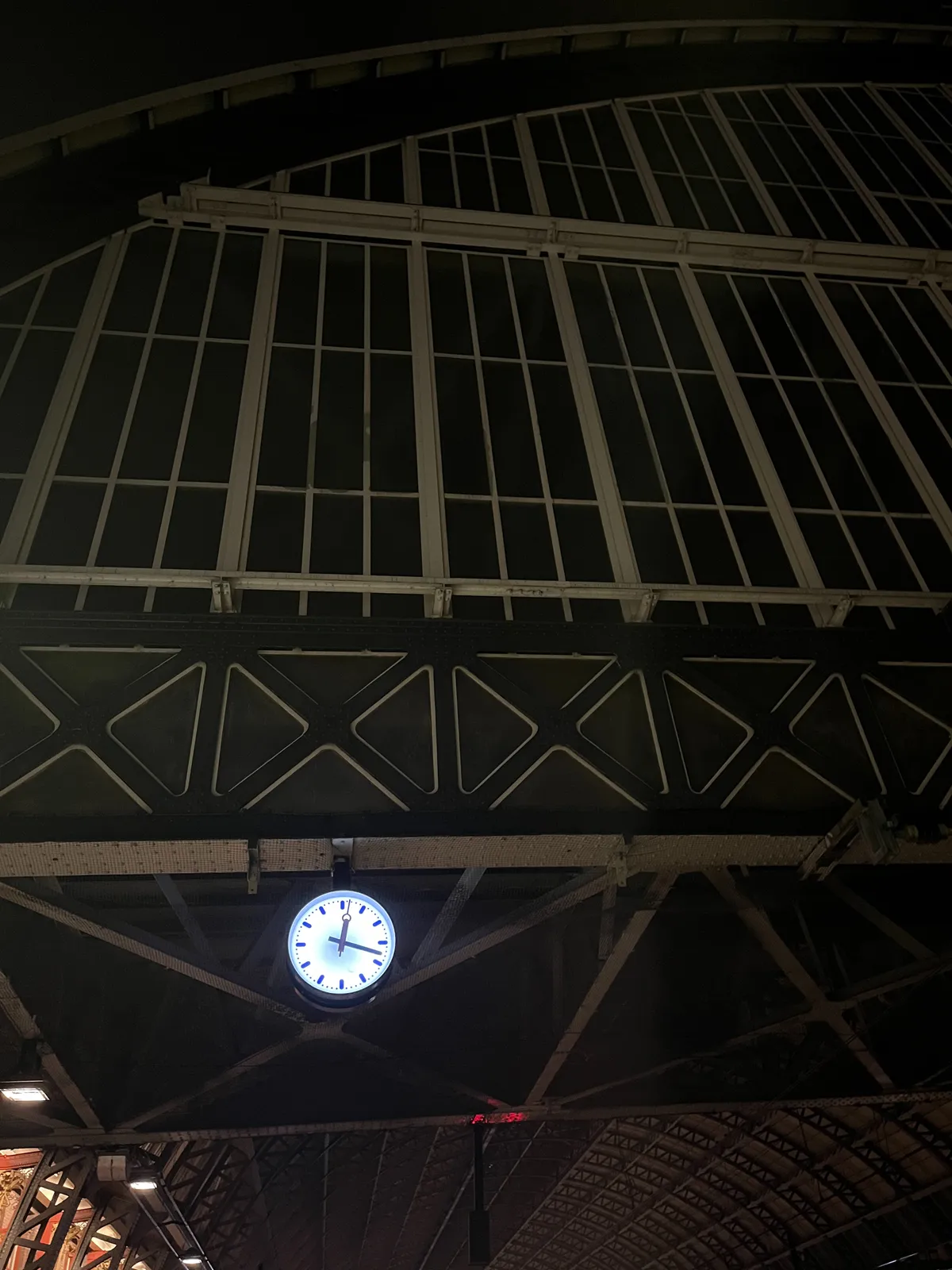 There is a clock attached to this huge dome of the Amsterdam Central train station, The clock points at 18 minutes past 12.