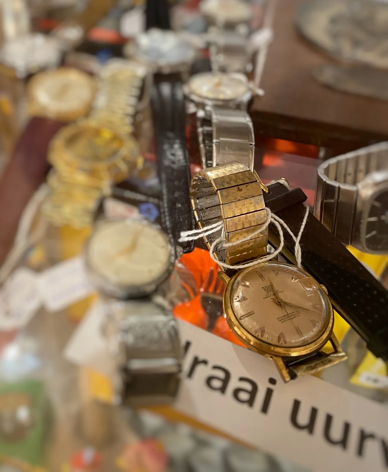 Many wrist watches on display here. Just one is clearly in focus. It points at 22 minutes past 12.