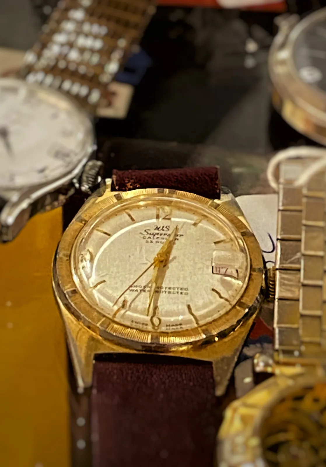A few wrist watches on display here. Just one is clearly in focus. It points at 29 minutes to one.