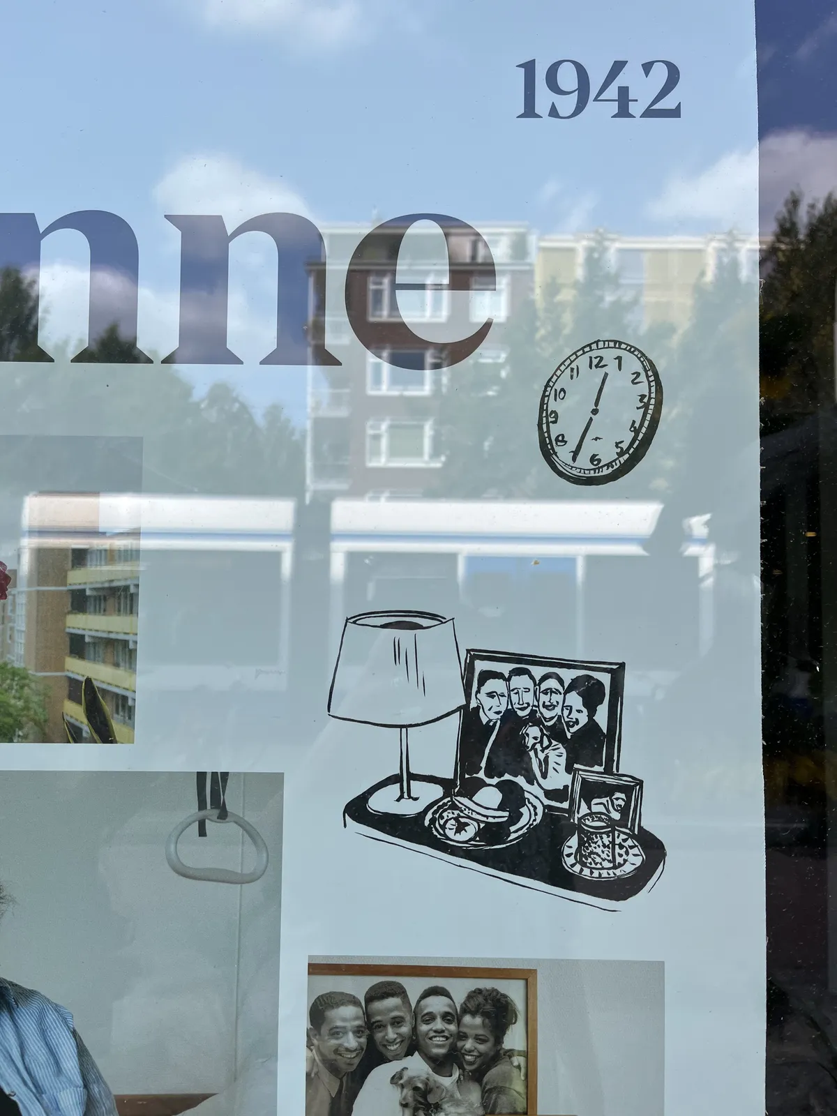 A picture of a detail of a poster, behind glass. A apartment building and a tram can be seen in the reflection. On the poster there are pictures and drawings of people, the year 1942, and a drawing of a clock that points at 35 minutes past twelve.