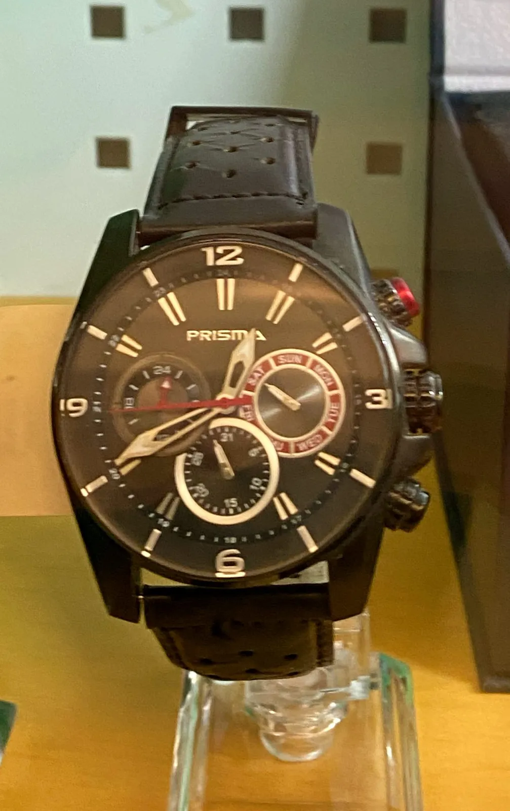 A large black wrist watch with quite a few extra dials for different functions. The time on this watch is 20 minutes to one.