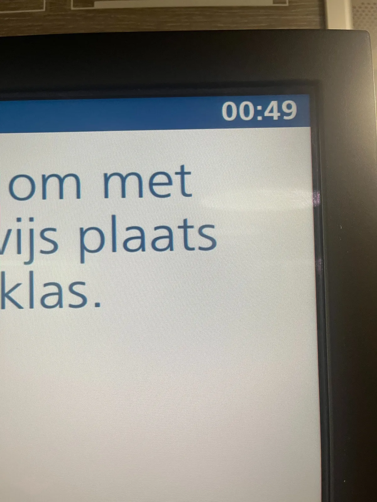 A close up of a part of a digital display. A few dutch words can be seen, but too few to show a complete sentence.  The time is shown in the right top corner as 00:49.