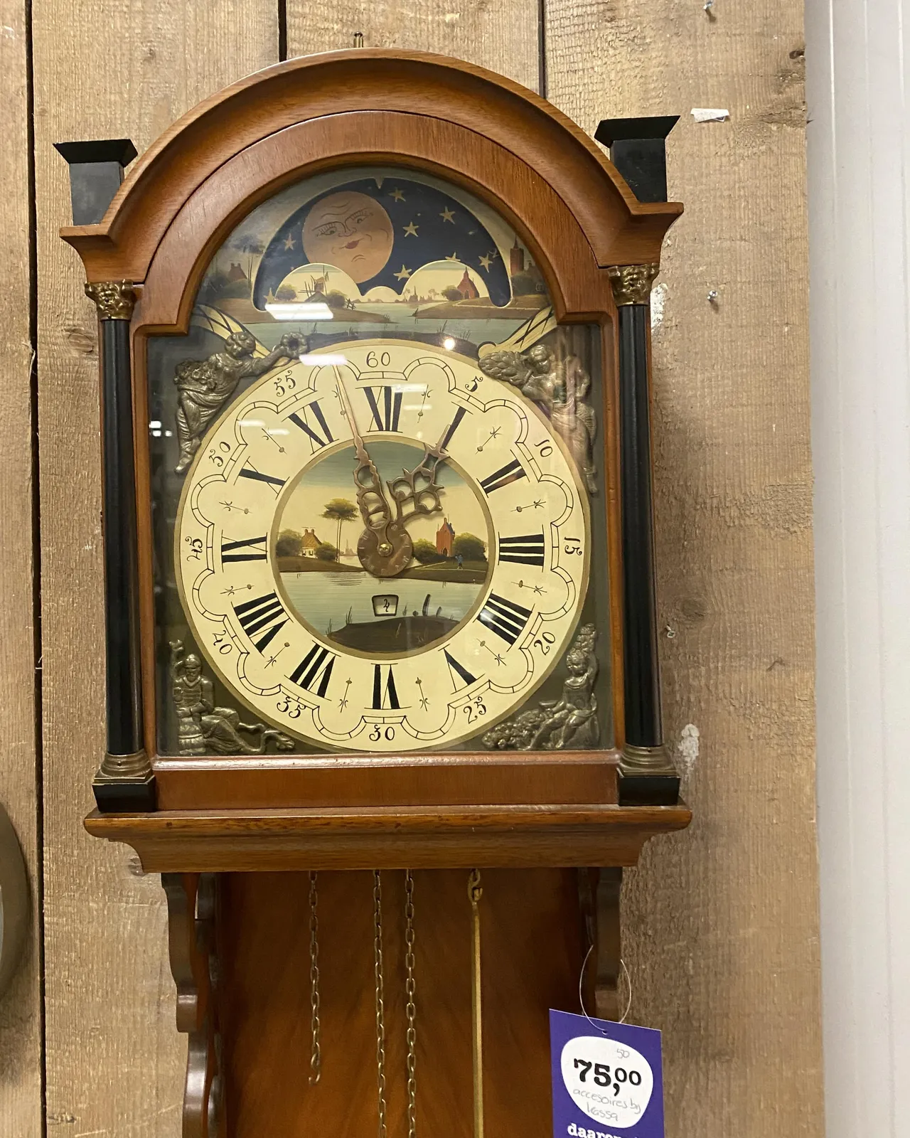 An old mechanical, wooden, ornamented clock. It seems to know whether it’s day or night, and it seems to have a mechanism to show the date. And of course it is able to show the time, which is 3 minutes to 1. 