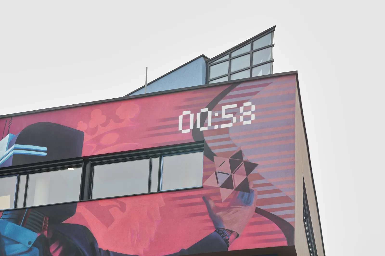 This building is painted. A hand and a crown can be seen. And a digital clock that says 00:58.