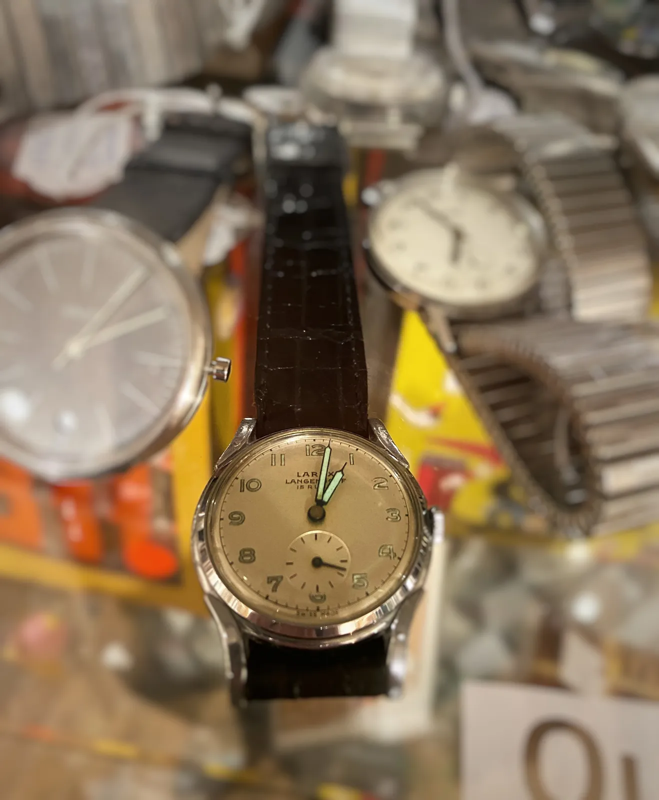 Quite a few wrist watches on display here. Just one of them is clearly in focus. It points at one minute past one.