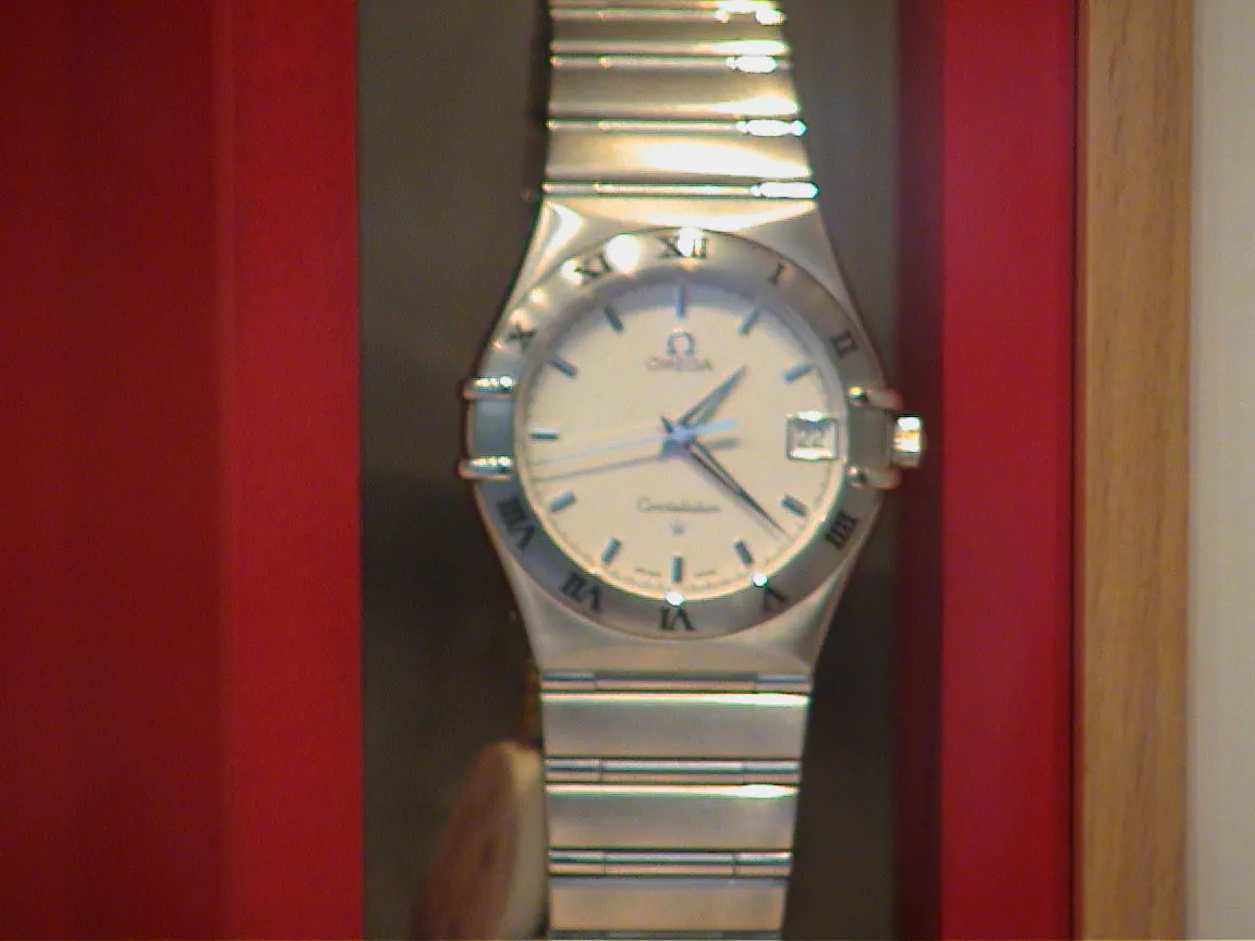 An Omega watch points at 22 past one.