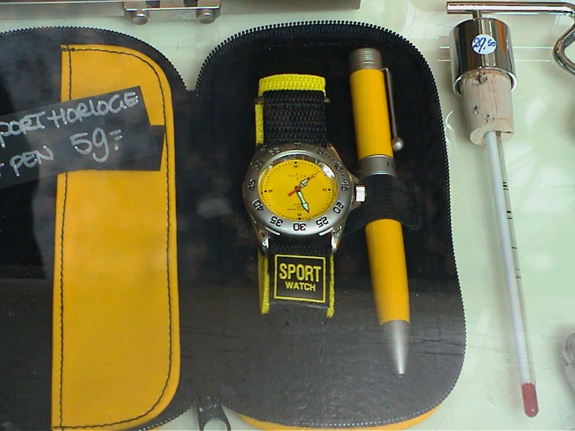 An orange/yellow/black watch points at 28 minutes past one.