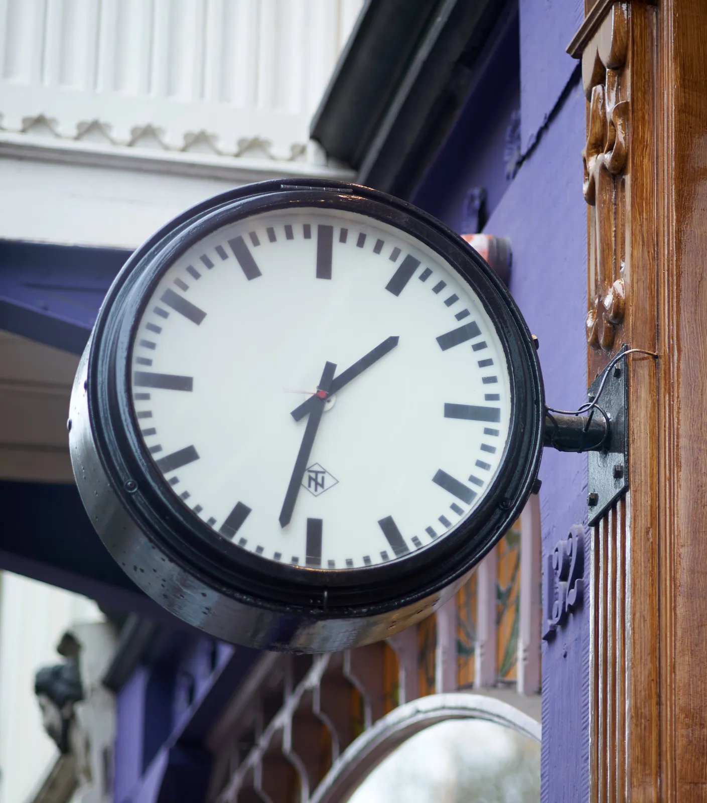 A clock attached to a colourful facade points at 32 past 1.