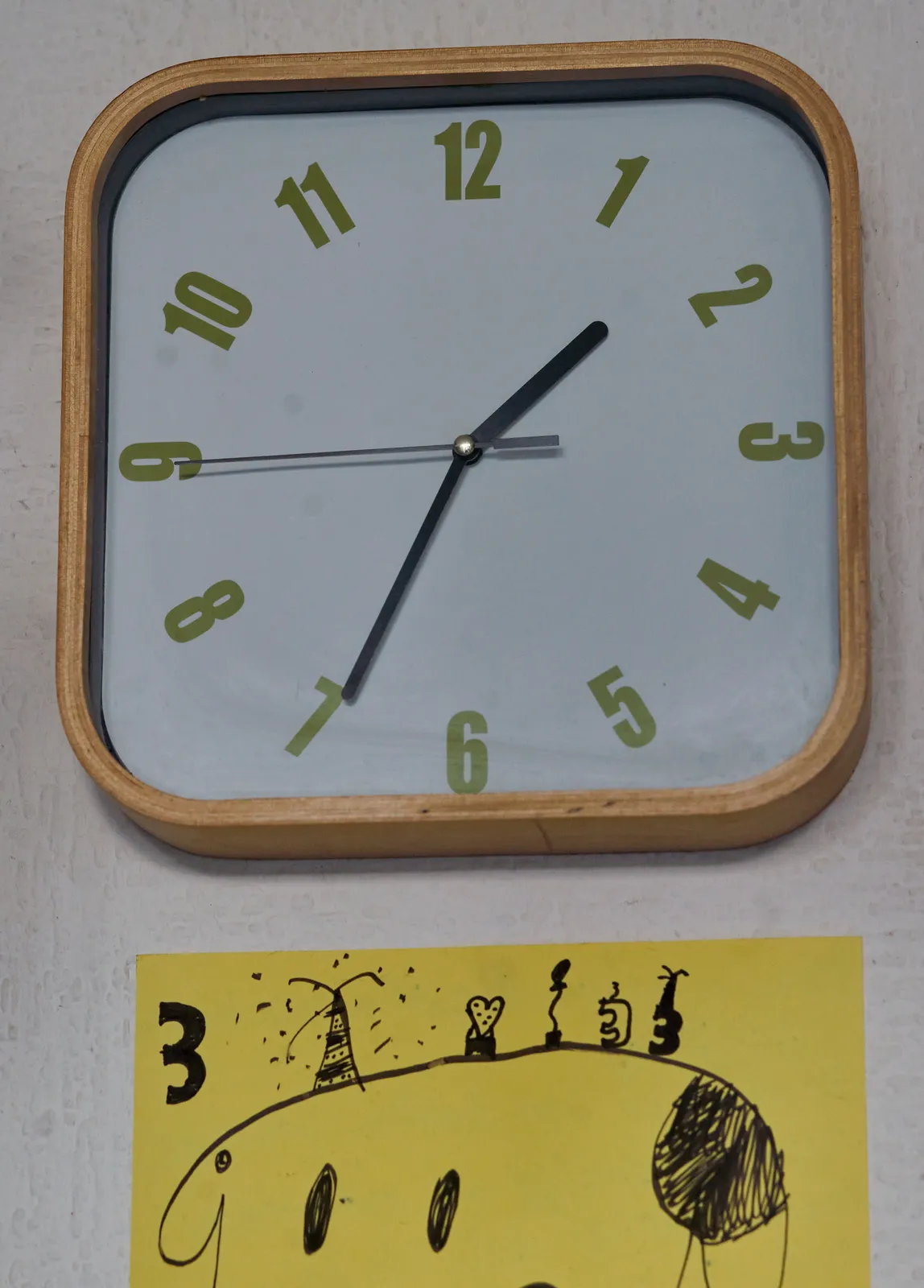 A wall clock points at thirty four minutes past one.