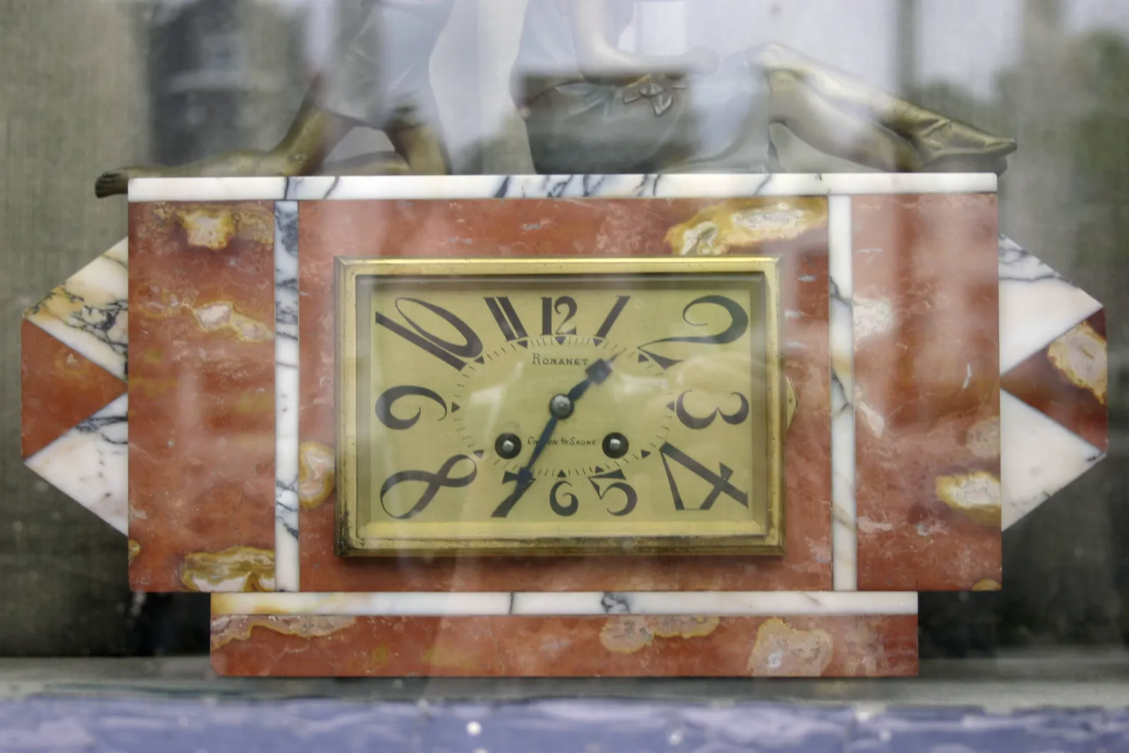 This art deco clock shows the time as 25 minutes to 2.