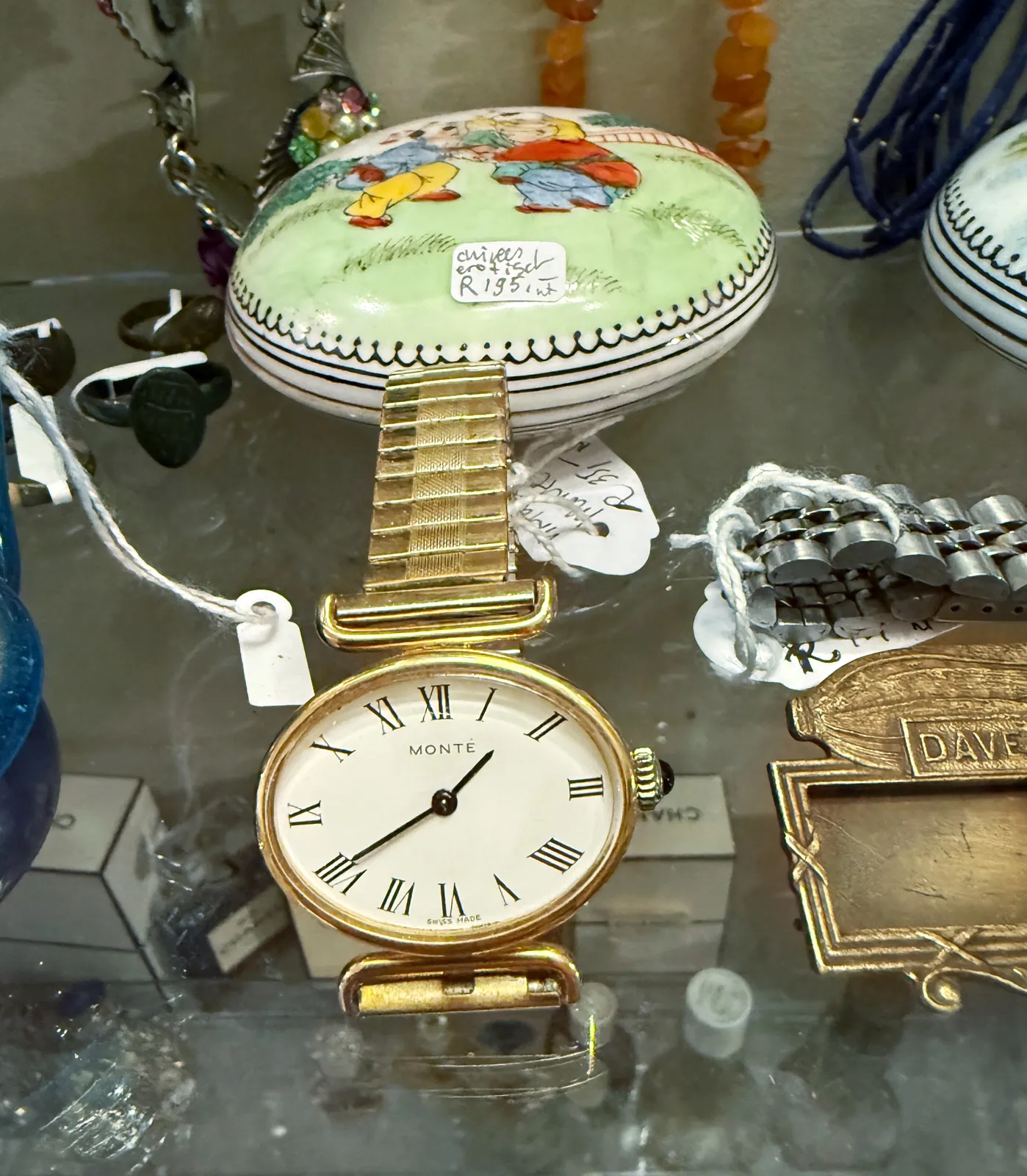 All kinds of things for sale. One of these things is an elegant wrist watch. It says Monté on its face, and it points at 20 minutes to two.