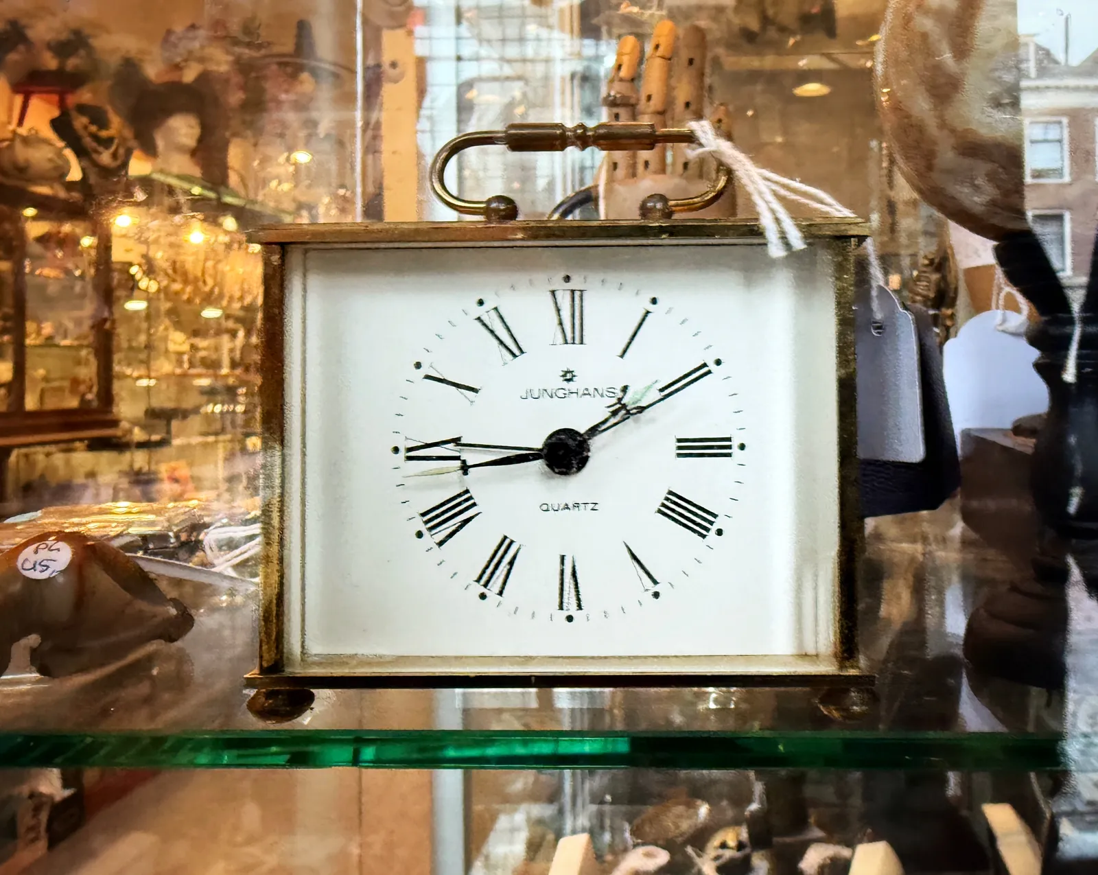 This is a table clock that looks older than it is. Roman numerals, and the words Junghans Quartz on the face. It points at 17 minutes to two.