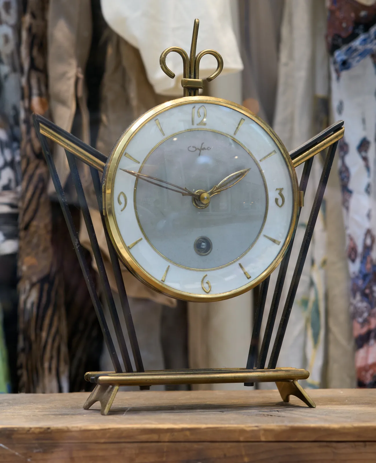 A pretty, art nouveau style clock. It points at 12 minutes to 2.