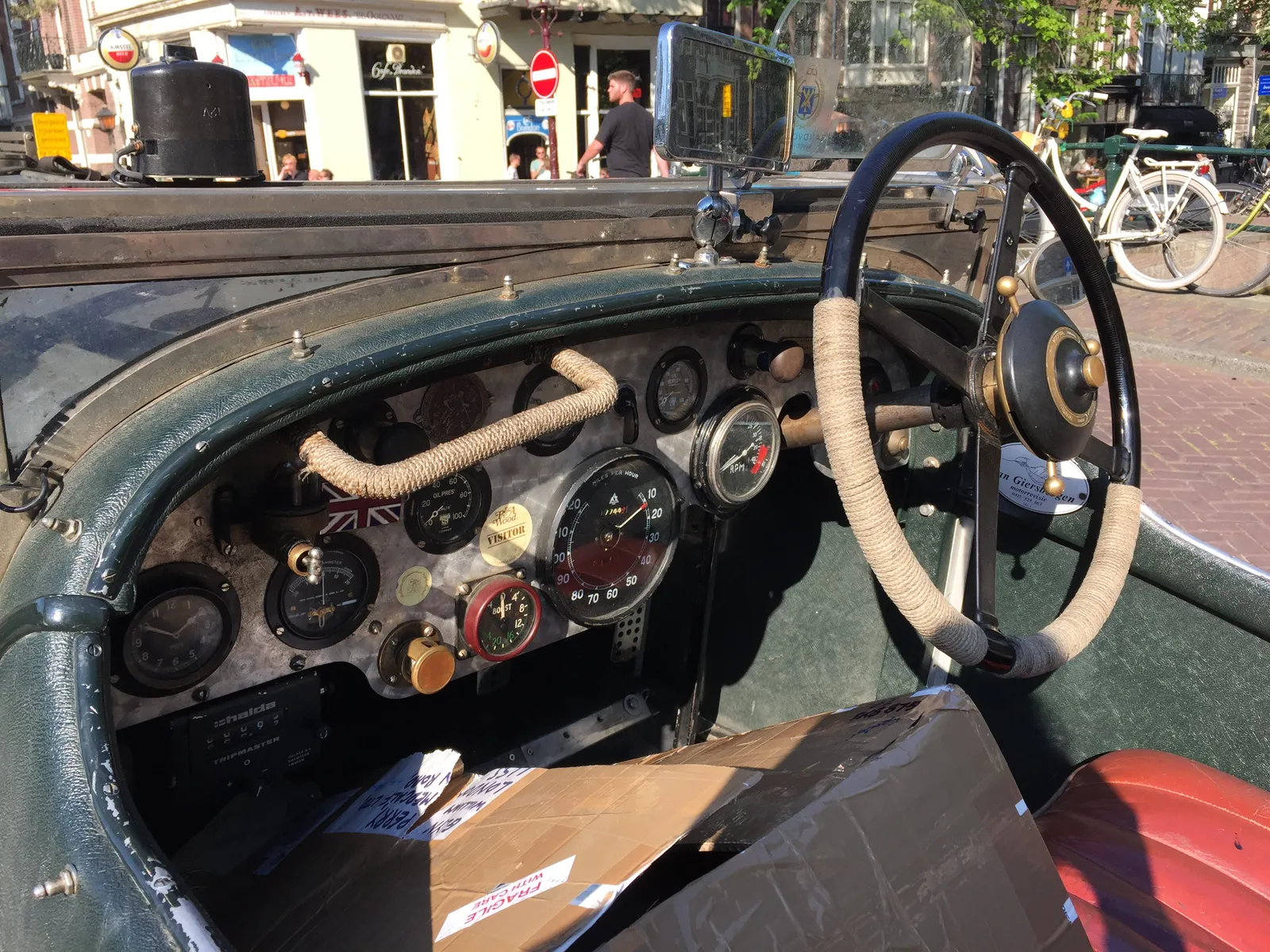 Looking at the dashboard of a very old car.  There are lots of dials on it, pointing at various things. There’s also a clock. On it it is approximately 10 minutes to 2.