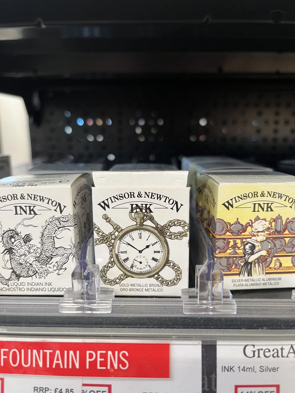 Some boxes on display with ink in them. On one of these boxes a clock os printed, which points at 9 minutes to two.