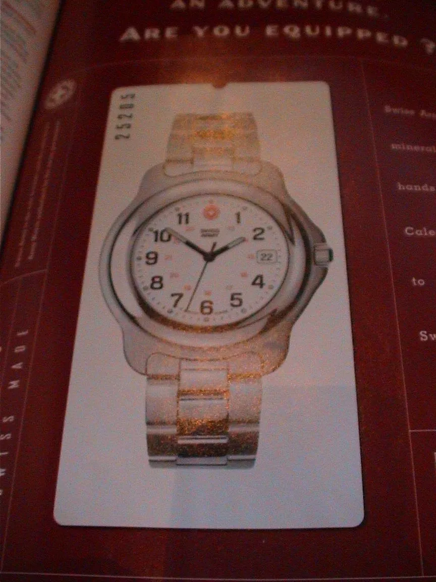 A clock in a magazine advertisement points at eight minutes to two.