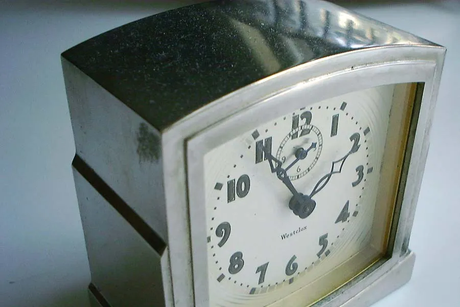 A silver clock points at five to 2.