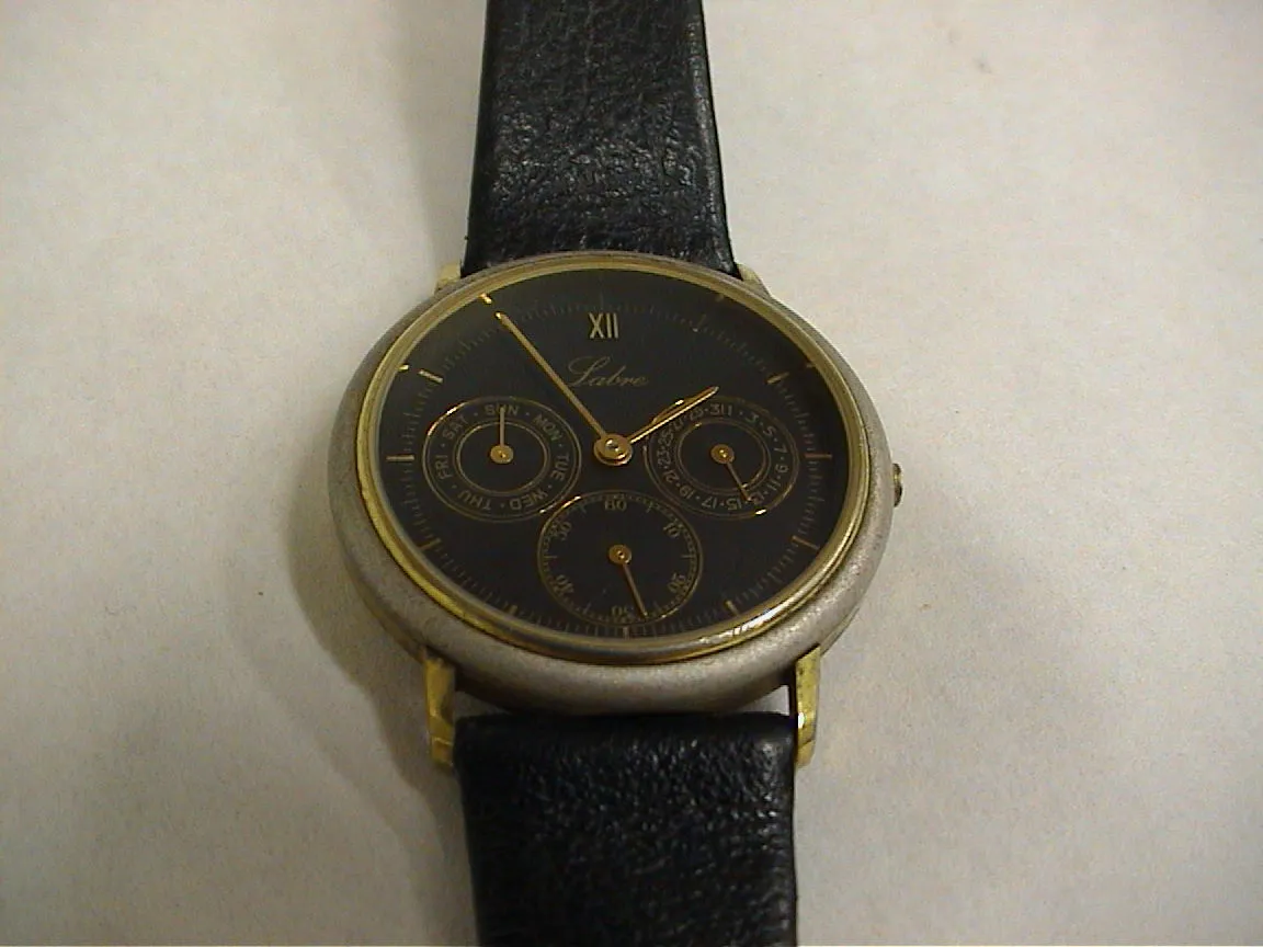 A black watch with golden hands points at five to two.