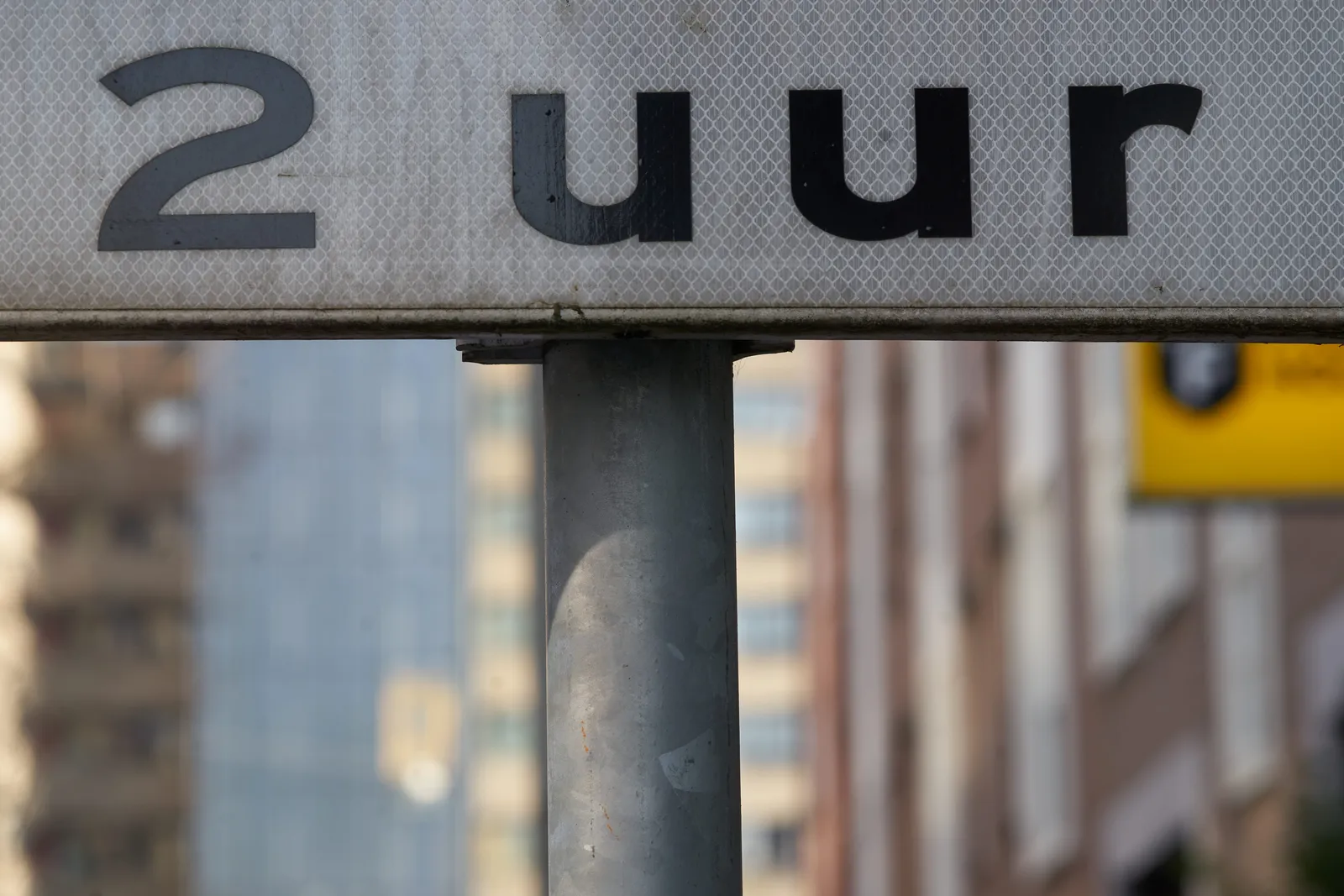 A sign on the street that says 2 uur, which means 2 hours, or 2 o’clock in Dutch.