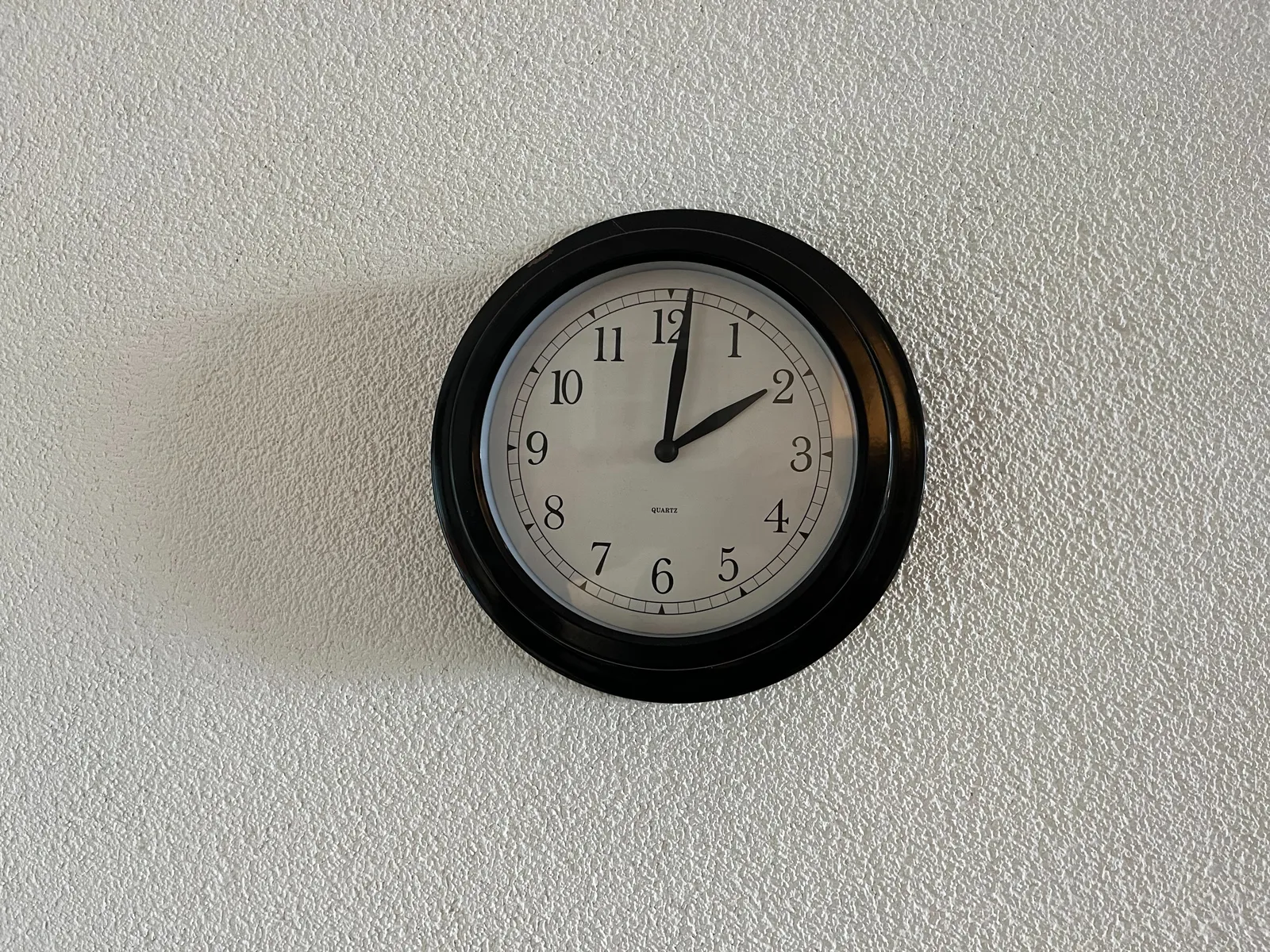A classic yet minimalist wall clock. It points at one minute past 2.