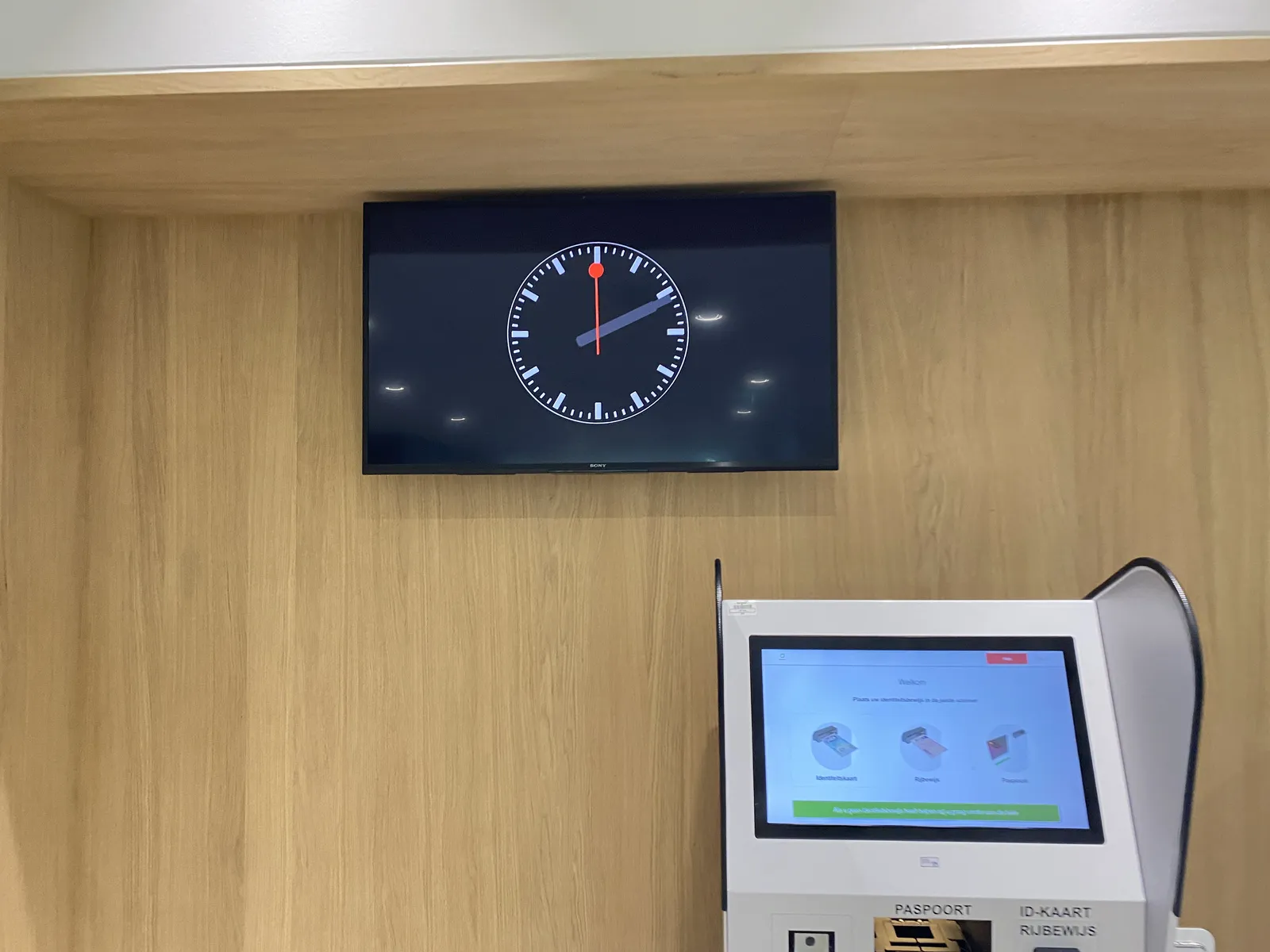 On a large digital screen you can see a representation of an analogue clock.n It points at 11 minutes past 2.
