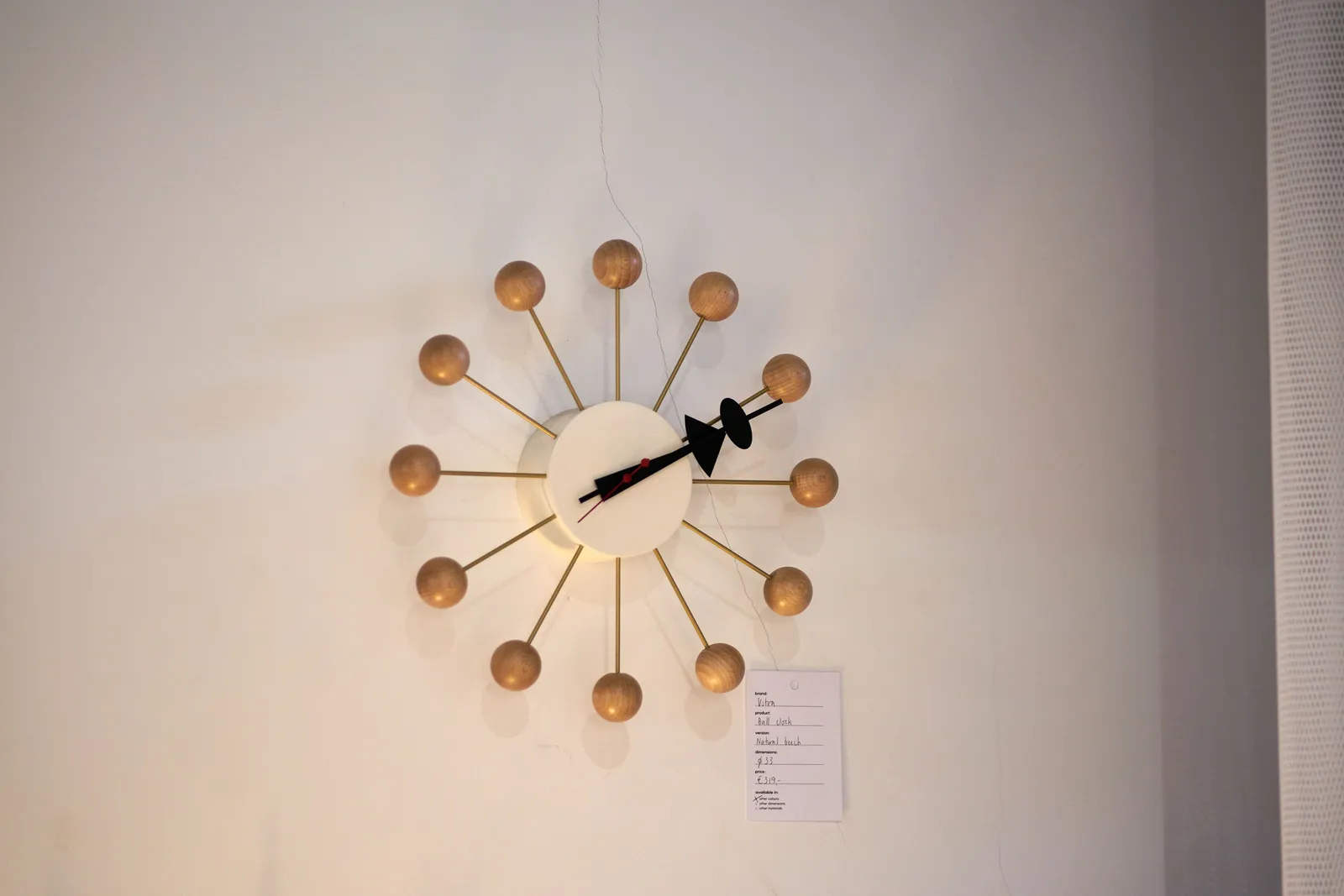 A clock with lots of balls seems to point at approximately 11 past 2.