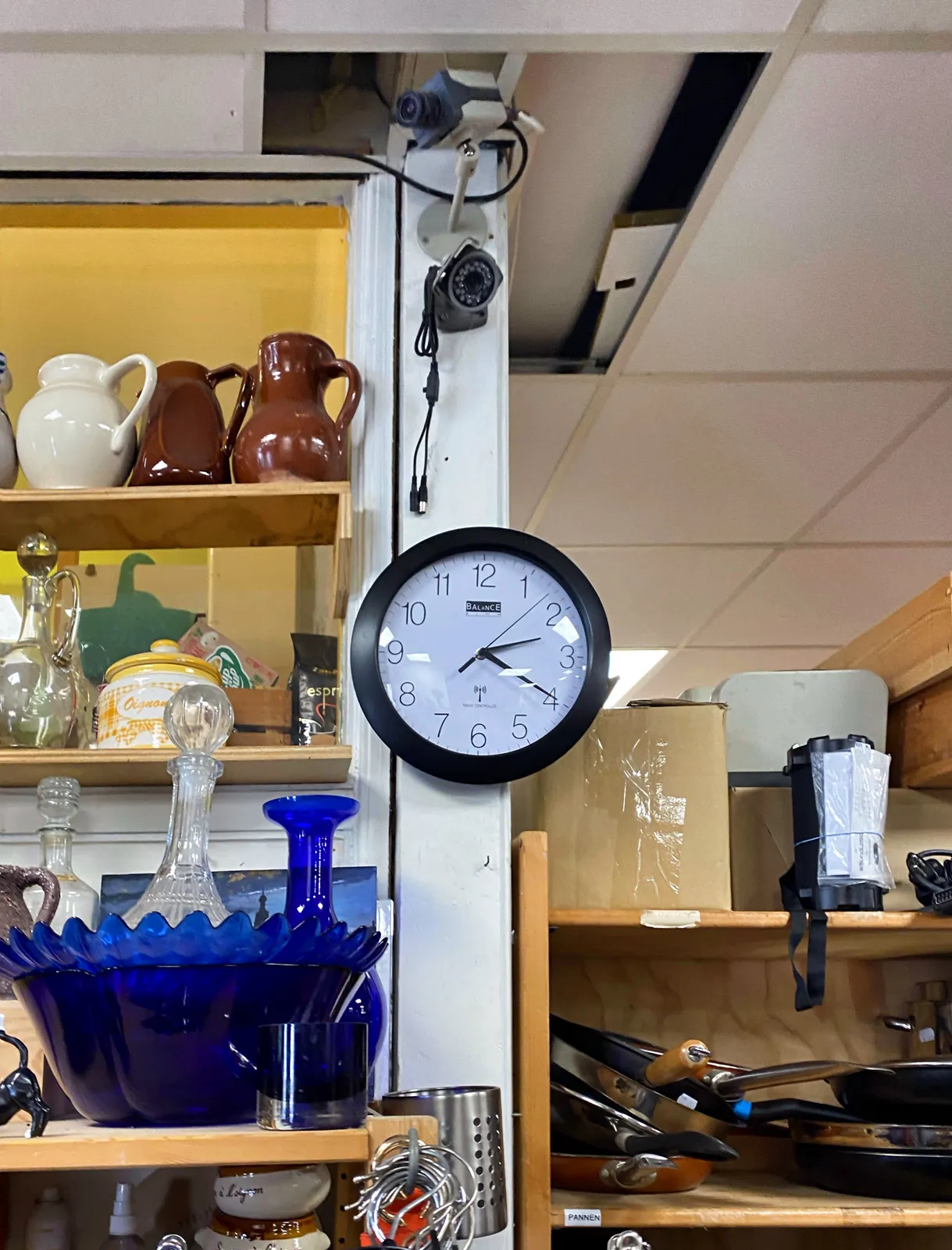 All kinds of kitchen utensils for sale here. There’s also a closed curcuit camera, and a clock. The clock points at 20 past 2.