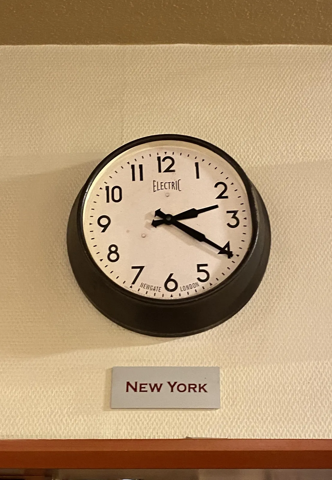 Below this clock is a sign that says New York. The clock points at 20 past 2.