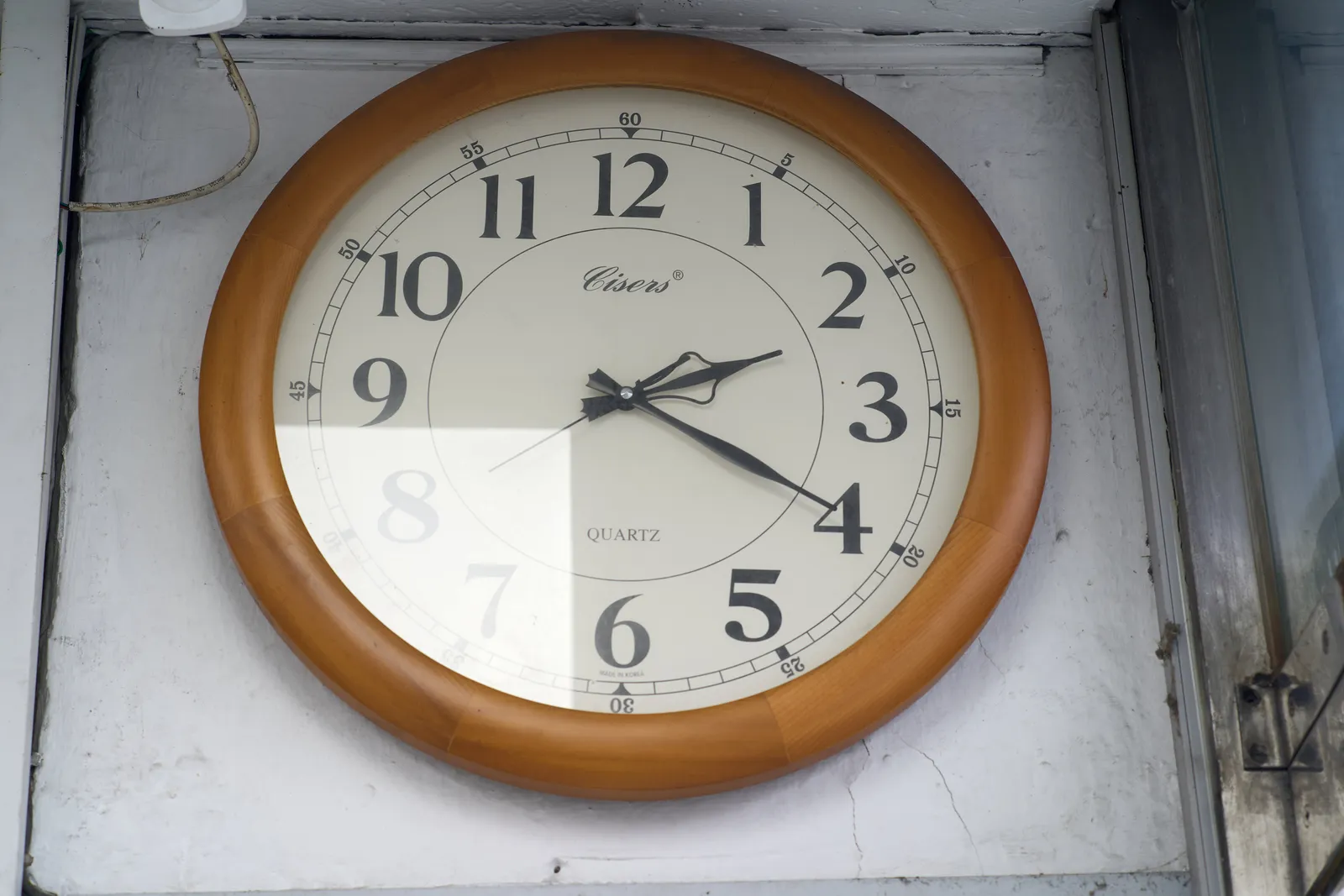 A wall clock. It says cisers quartz on its face, and it points at 20 past 2.