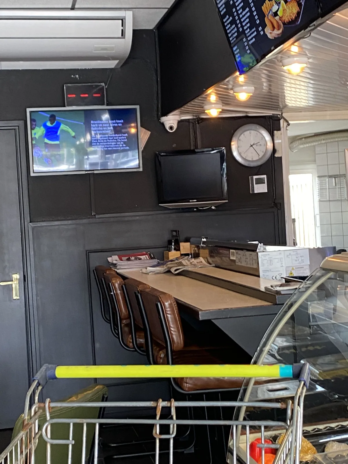 This looks like a snack bar. There’s a clock on the wall. It points at 24 minutes past 2.