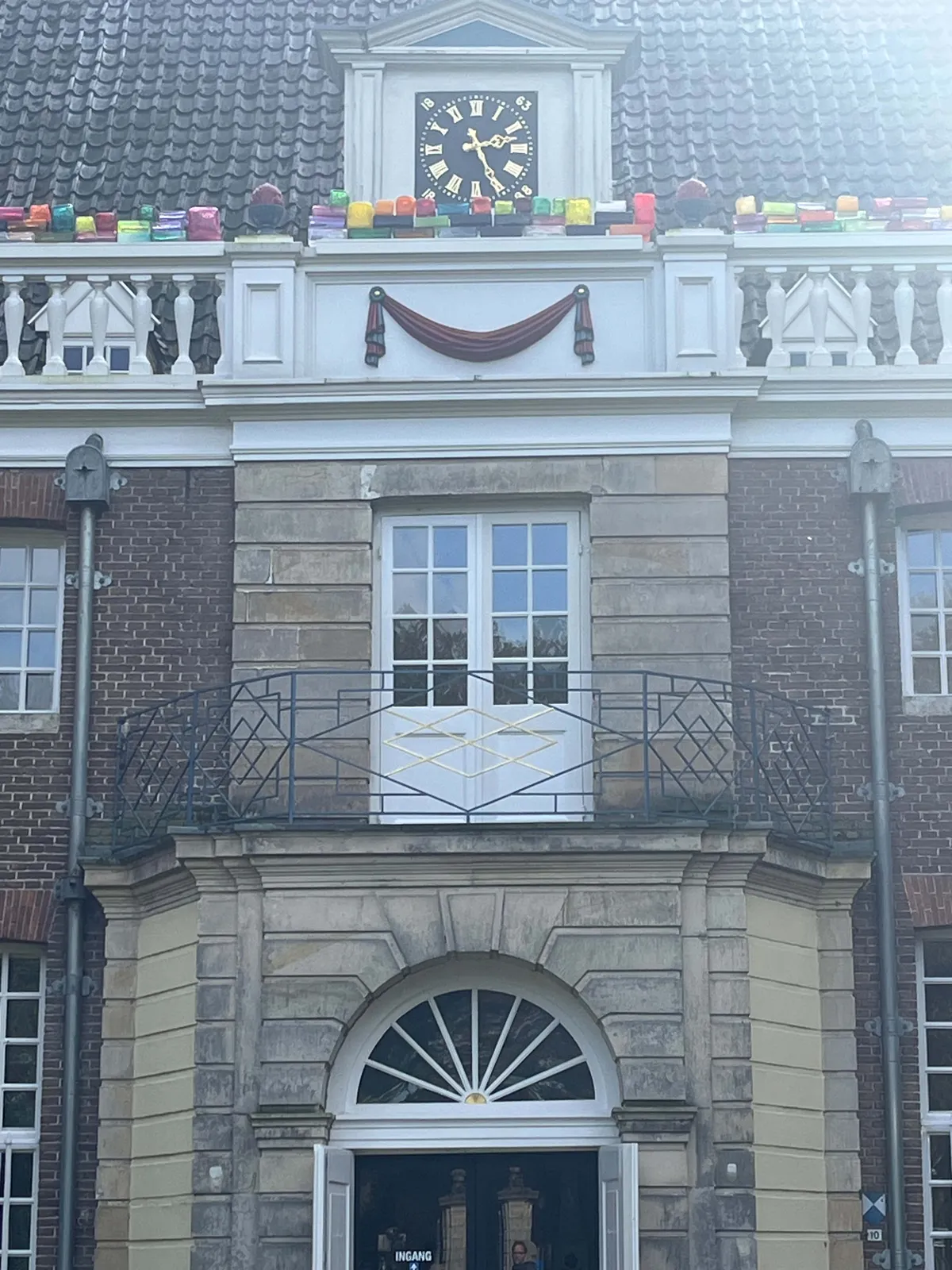 The entrance of a castle with a clock. It points at 26 minutes past 2.