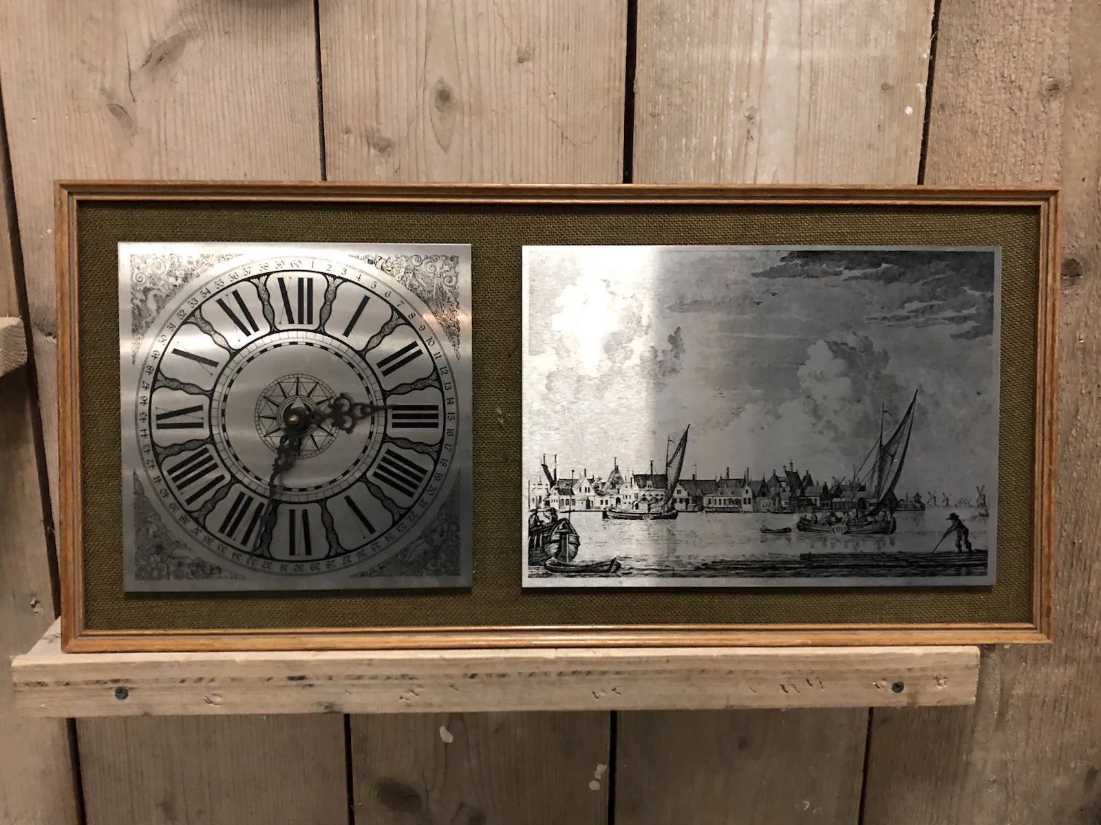 Inside a frame on the right there’s an etch plate with a classic Dutch landscape with boats on the water. On the left there’s an etch plate with a clock on it. It points at 32 minutes past 2.