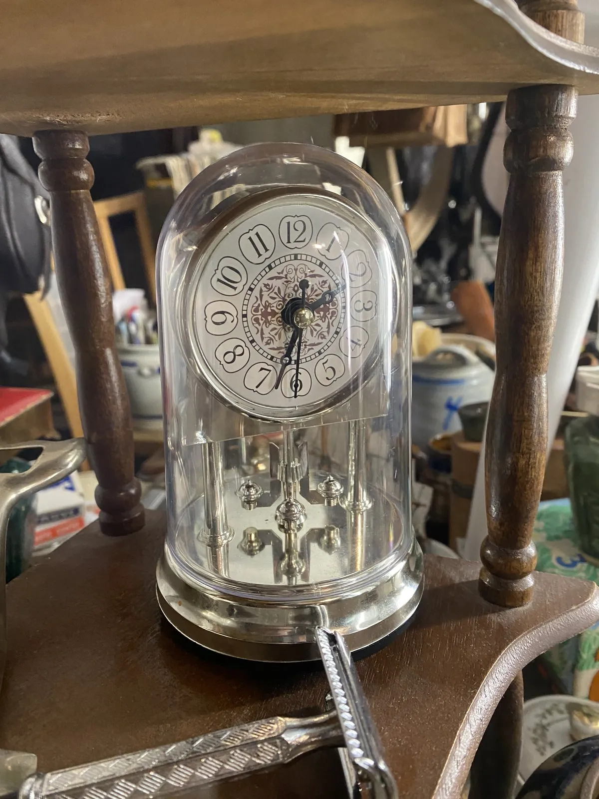 This looks like an old mechanical, metal clock that’s placed inside a glass cylinder. But it could just as well all be plastic. It’s in a thrift shop and it points at 3 past 2.