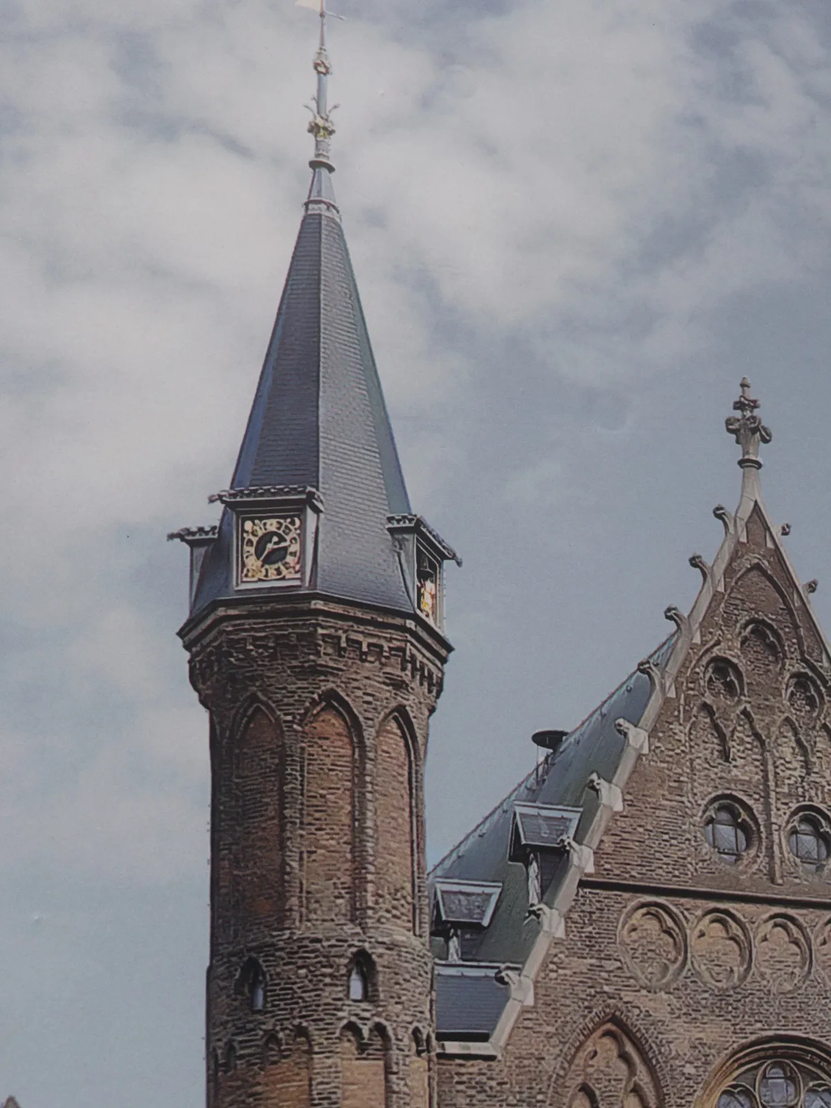 A picture taken from a picture. There’s a church with a tower on this picture. On the tower there’s a clock that points at 24 minutes to 3
