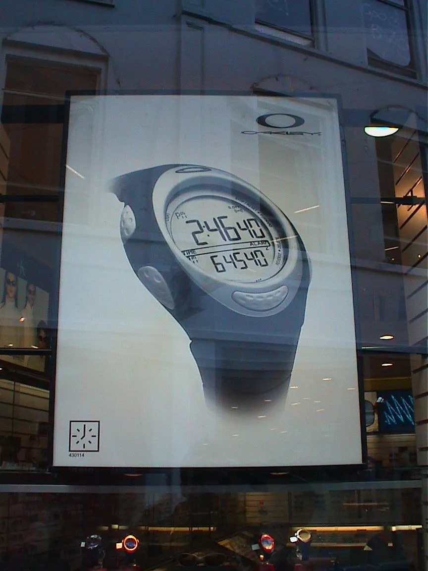 A large watch on a large poster in a shop shows that it is 2:46