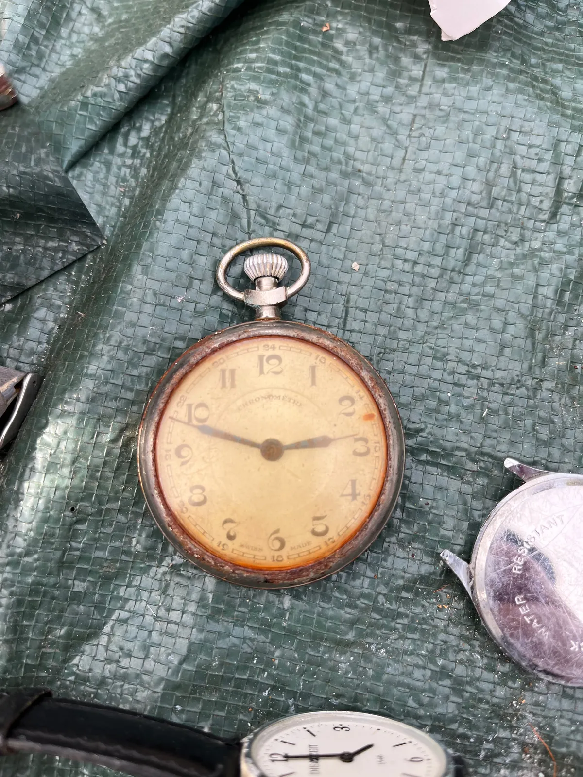 An old hand watch, the glass is very yellow, points at 11 minutes to three.