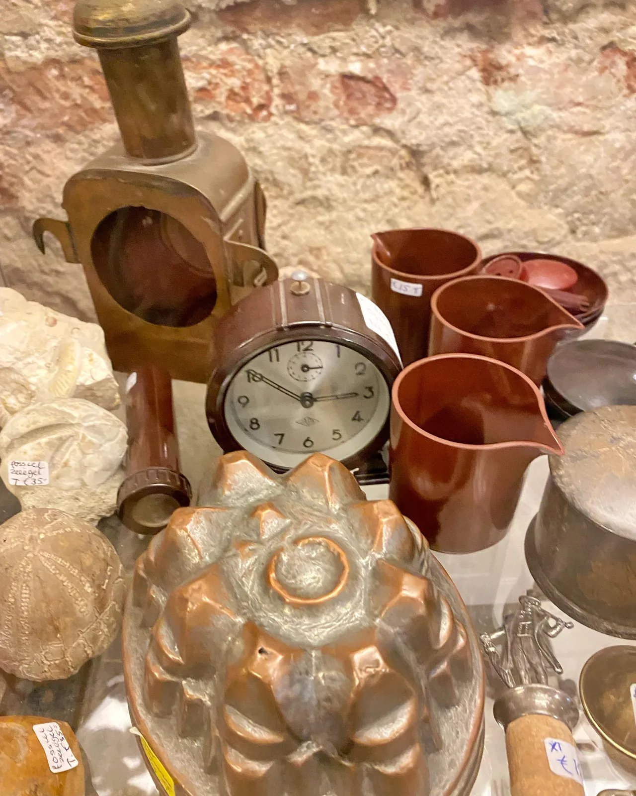 Various things for sale. Among these things there’s a clock. It points at 9 minutes to 3.