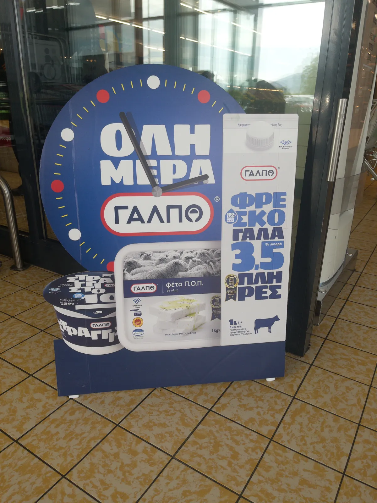 A cardboard advertisement for diary products in the shape of a clock that points at 4 minutes to three