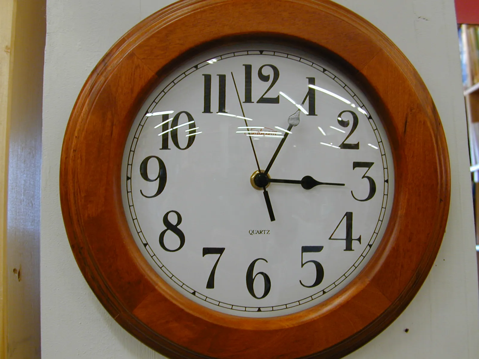 A wall clock points at five past three.