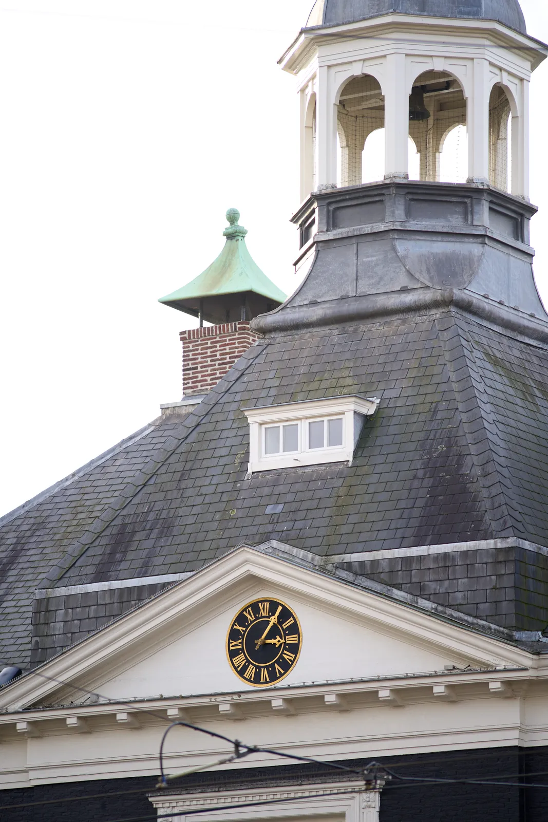 A clock on some sort of old tower. It points at 5 past 3.